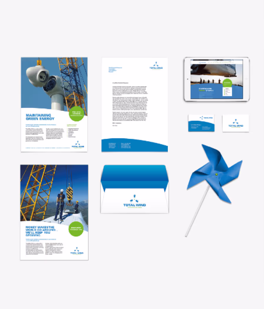 Collection of branded materials for Total Wind including two flyers featuring wind turbines and workers, a letterhead, a tablet showing a webpage, two business cards, a blue and white envelope, and a blue pinwheel.